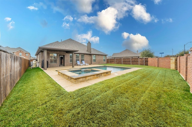 back of property with a swimming pool with hot tub, a yard, and a patio