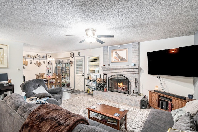 living room featuring a textured ceiling, a fireplace, wood finished floors, and a ceiling fan