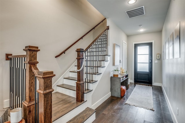 entryway with dark wood-style floors, visible vents, and baseboards