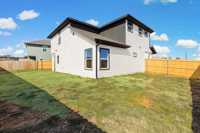 rear view of house featuring a lawn