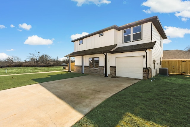 back of property featuring a yard, a garage, and central air condition unit