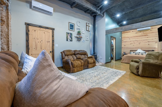 living room with a towering ceiling, concrete flooring, a wall unit AC, and wood walls