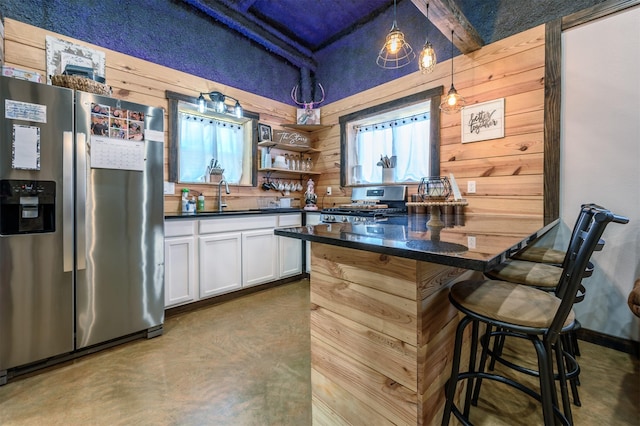 kitchen with appliances with stainless steel finishes, a breakfast bar, decorative light fixtures, white cabinetry, and sink