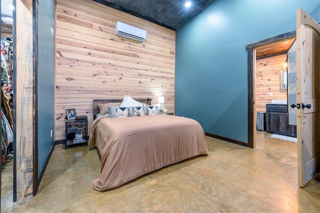 bedroom with concrete flooring, a wall mounted air conditioner, and wood walls