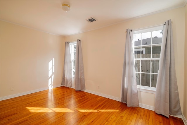 empty room featuring hardwood / wood-style flooring and crown molding