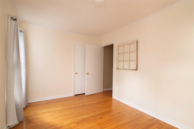 unfurnished room featuring ornamental molding and light wood-type flooring