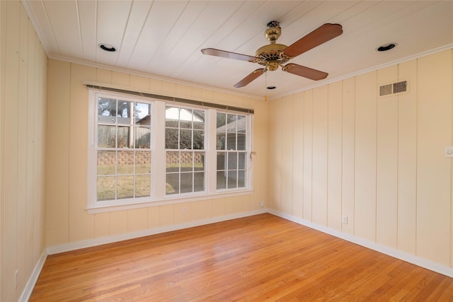 unfurnished room featuring ornamental molding, a wealth of natural light, and light wood-type flooring