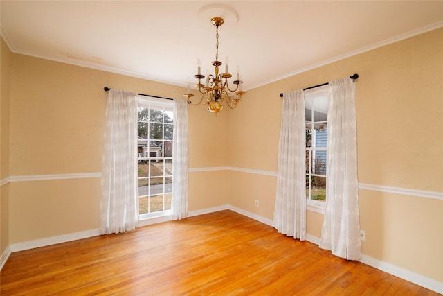 unfurnished dining area with wood-type flooring, ornamental molding, and a chandelier