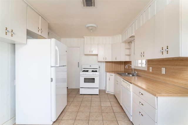 kitchen with light tile patterned flooring, sink, white cabinetry, tasteful backsplash, and white appliances