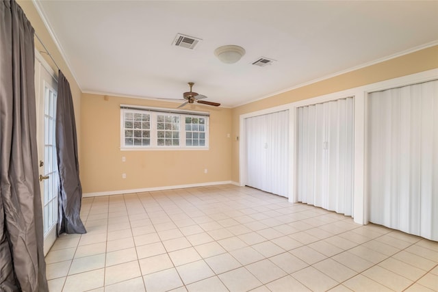 empty room featuring ornamental molding, light tile patterned flooring, and ceiling fan