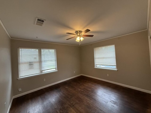 empty room featuring dark hardwood / wood-style flooring, ornamental molding, and ceiling fan