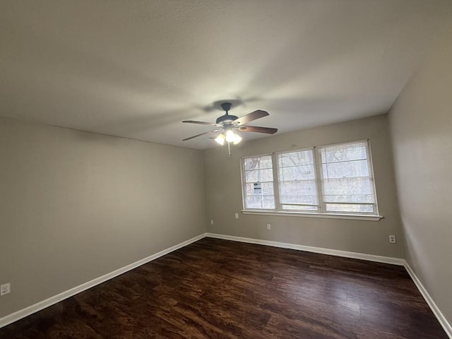 empty room with ceiling fan and dark hardwood / wood-style flooring