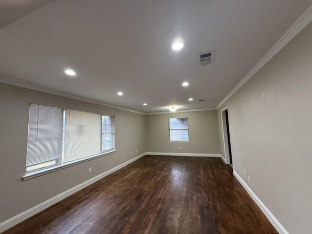 empty room with dark wood-type flooring and ornamental molding