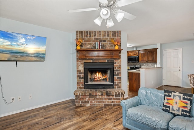 living area with ceiling fan, a fireplace, wood finished floors, and baseboards