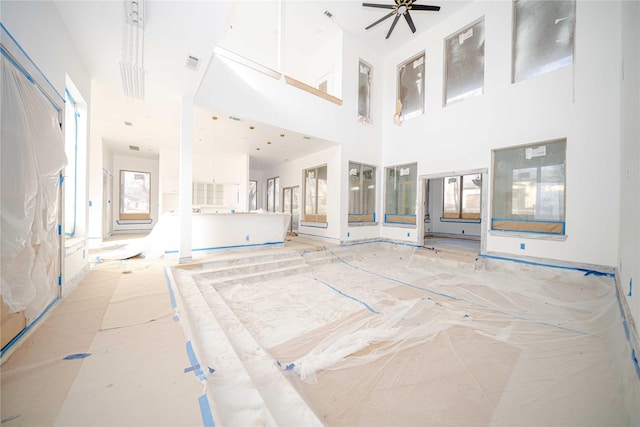 living room featuring a towering ceiling and ceiling fan