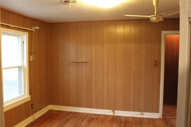 unfurnished room featuring hardwood / wood-style floors and wood walls