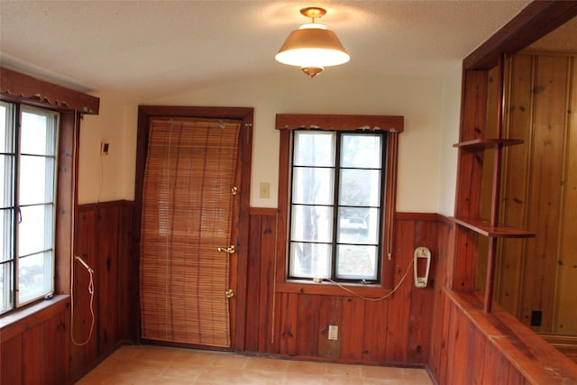 doorway to outside with a healthy amount of sunlight and wooden walls