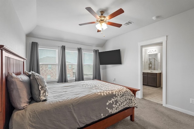 carpeted bedroom featuring ceiling fan, ensuite bath, and lofted ceiling