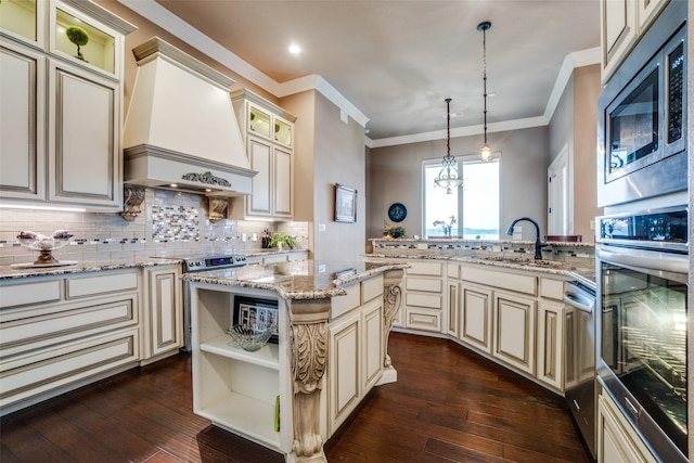 kitchen featuring premium range hood, hanging light fixtures, stainless steel appliances, a center island, and cream cabinets