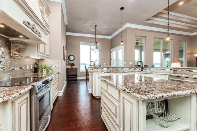 kitchen with light stone countertops, stainless steel electric stove, a kitchen island, and pendant lighting