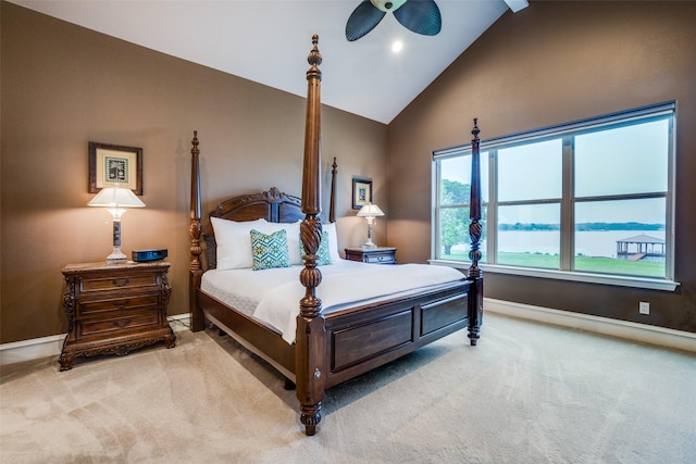 bedroom featuring high vaulted ceiling, light colored carpet, and a water view