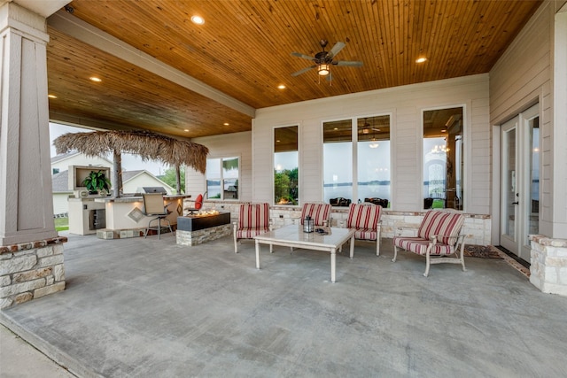 view of patio / terrace with ceiling fan, an outdoor living space, exterior bar, and exterior kitchen