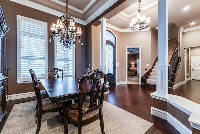 dining room featuring crown molding, dark wood-type flooring, decorative columns, a tray ceiling, and a chandelier