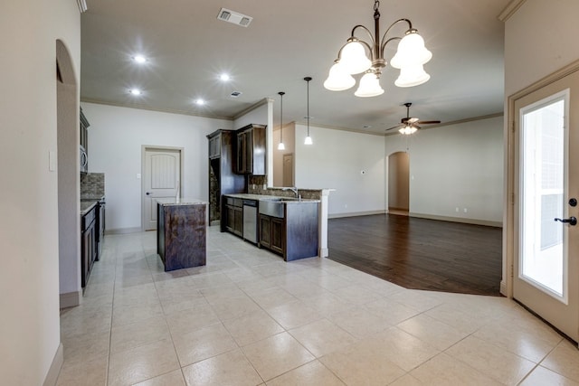 kitchen with crown molding, a center island, dark brown cabinets, hanging light fixtures, and dishwasher