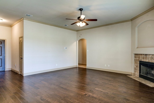 unfurnished living room featuring ceiling fan, ornamental molding, dark hardwood / wood-style flooring, and a tile fireplace