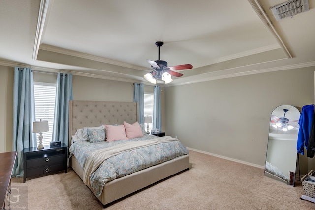 carpeted bedroom with crown molding, ceiling fan, and a raised ceiling