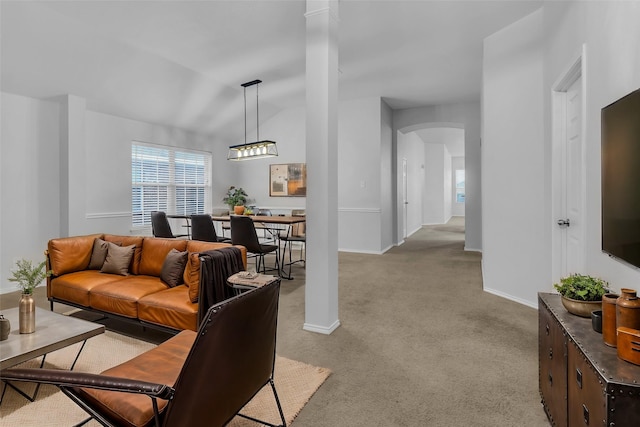 carpeted living room with vaulted ceiling and ornate columns