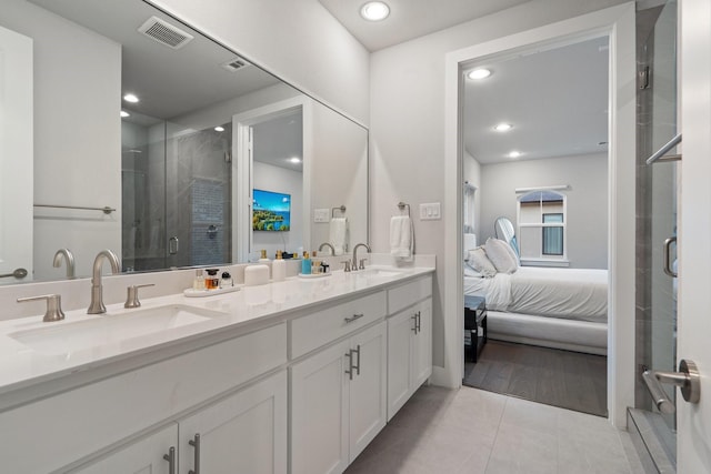 bathroom with tile patterned floors, a shower with door, and vanity