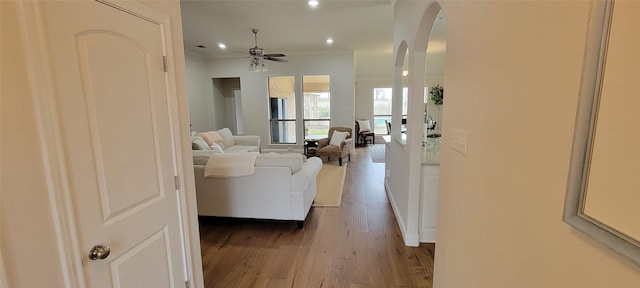 living room featuring crown molding, hardwood / wood-style floors, and ceiling fan