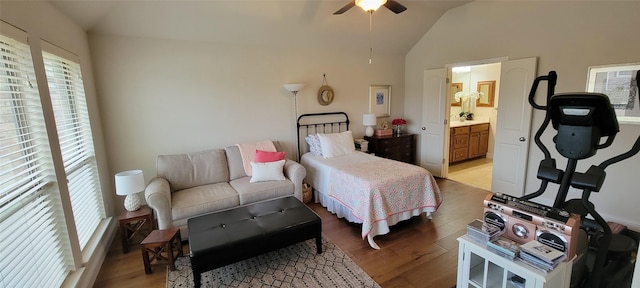 bedroom with lofted ceiling, ensuite bathroom, and light wood-type flooring