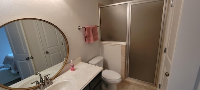 bathroom featuring tile patterned floors, vanity, toilet, and an enclosed shower