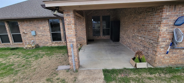 view of exterior entry with a patio area