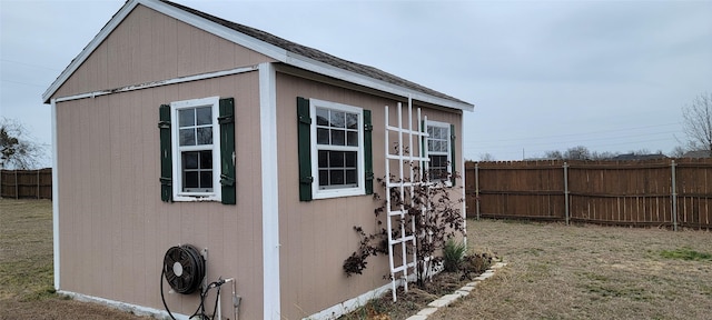 view of side of home with a lawn and a storage unit