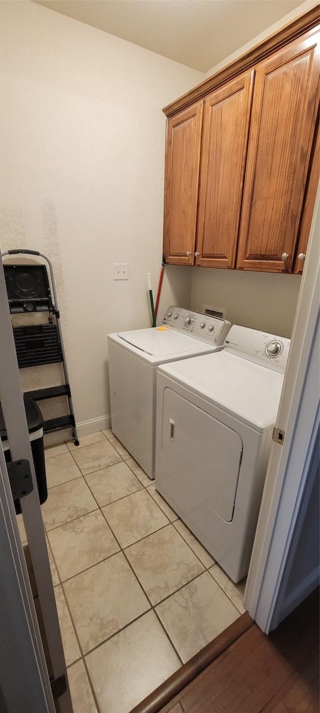 washroom featuring cabinets and washing machine and clothes dryer