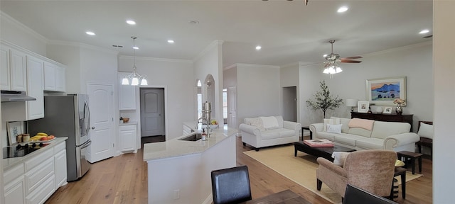 kitchen featuring sink, light wood-type flooring, white cabinets, light stone counters, and black electric cooktop