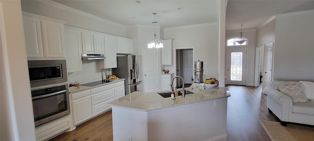 kitchen with white cabinetry, stainless steel appliances, sink, and pendant lighting