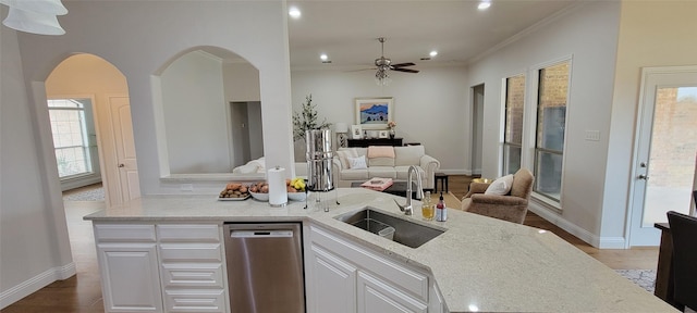 kitchen with white cabinetry, stainless steel dishwasher, light stone countertops, and sink