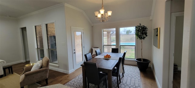 dining room with hardwood / wood-style flooring, ornamental molding, and a chandelier