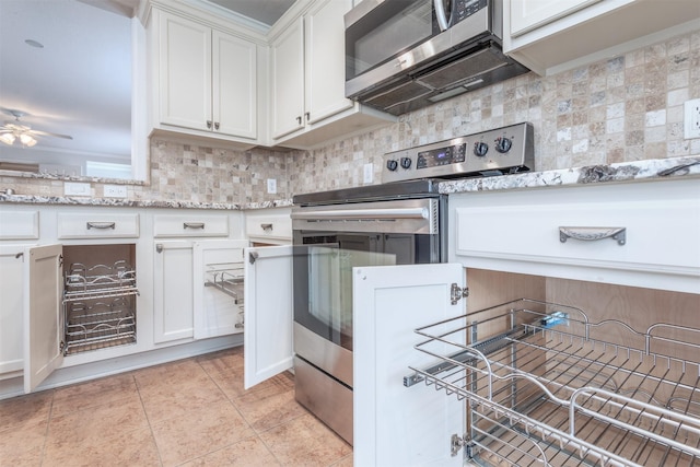 kitchen featuring light tile patterned flooring, white cabinetry, backsplash, stainless steel appliances, and light stone countertops