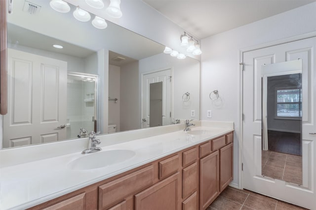 bathroom with walk in shower, vanity, toilet, and tile patterned flooring