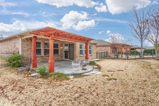 back of property with a pergola and a patio area