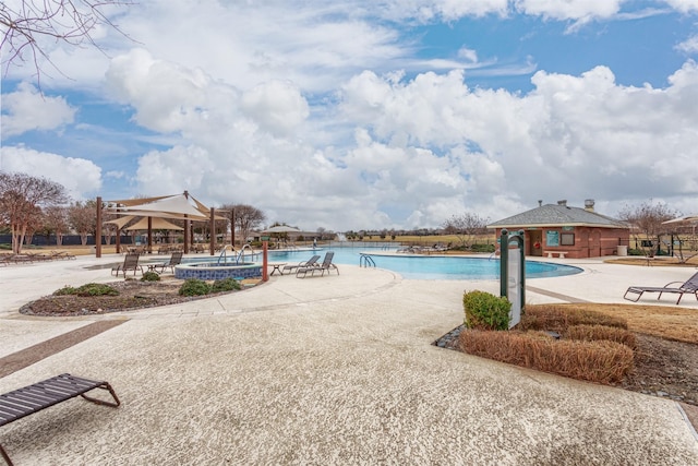 view of pool featuring a jacuzzi and a patio area