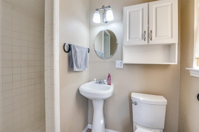 bathroom with tiled shower and toilet