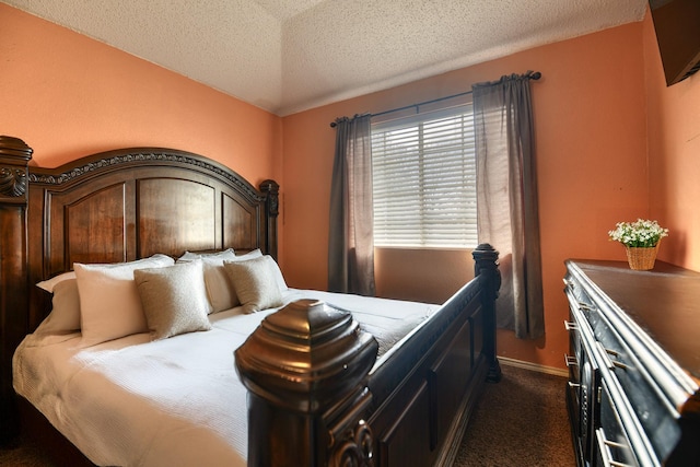 bedroom with dark carpet and a textured ceiling