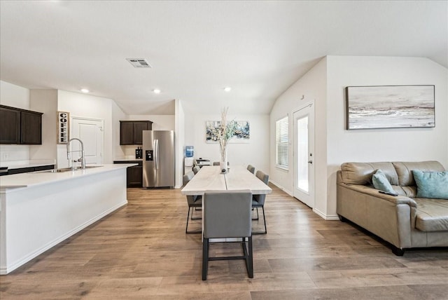 dining area with visible vents, vaulted ceiling, baseboards, recessed lighting, and light wood-style flooring