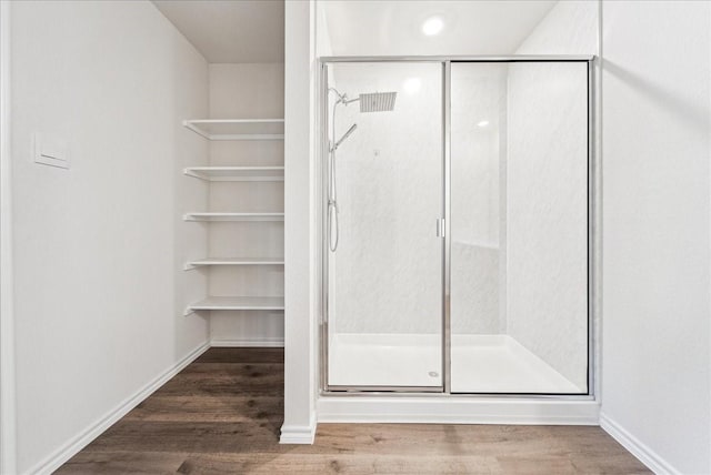 full bath featuring baseboards, a stall shower, and wood finished floors